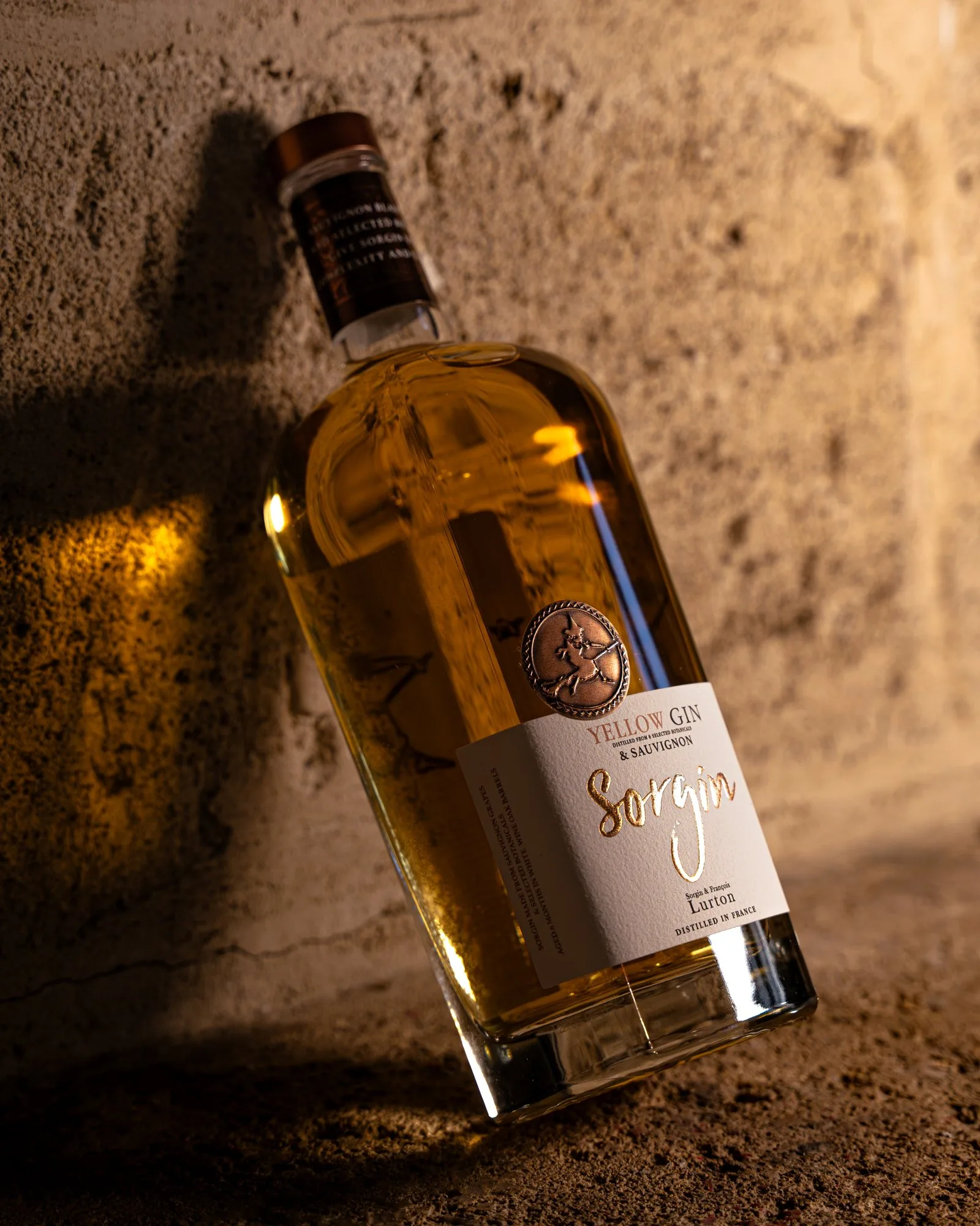 Bouteille de gin Sorgin posée contre un mur de pierre