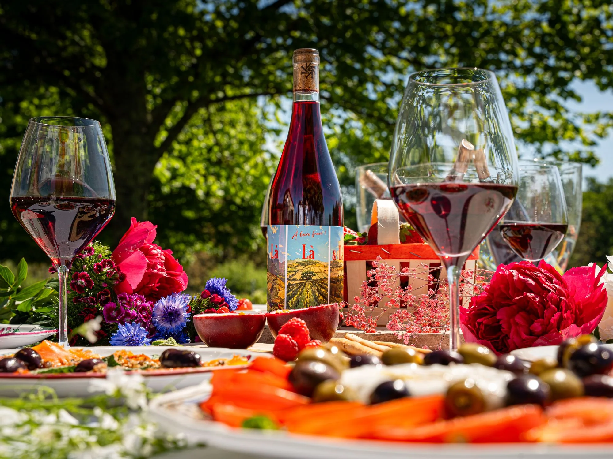 Bouteille et verres de vin sur une table fleurie