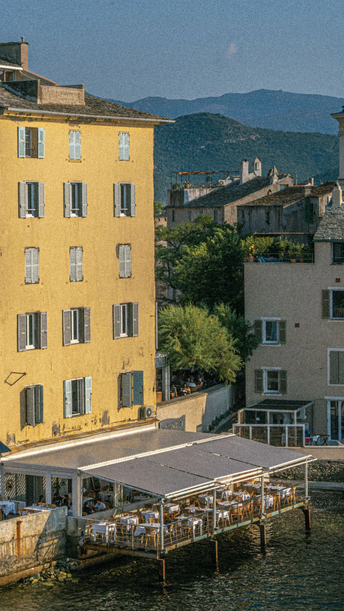 Immeuble jaune et terrasse sur pilotis
