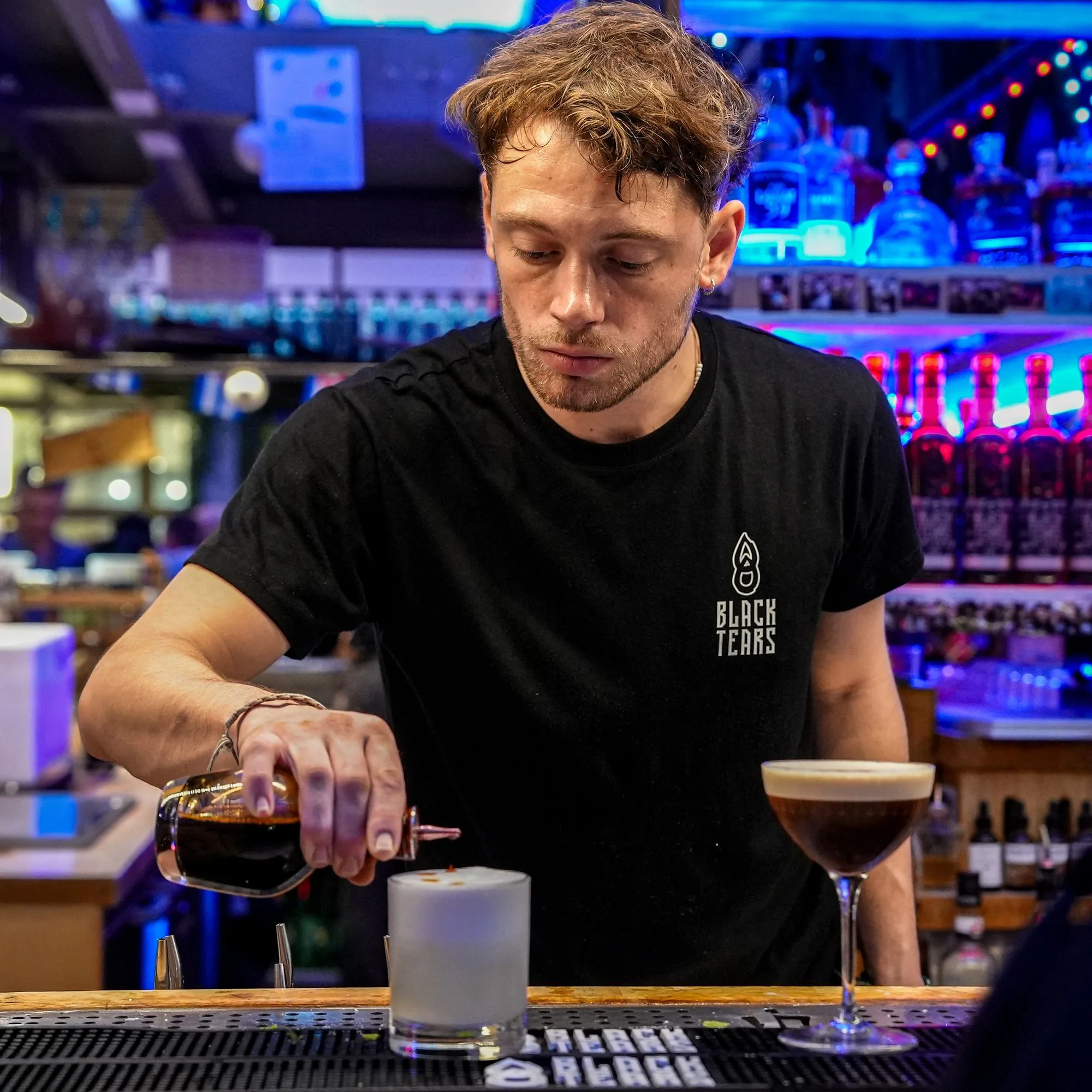 Barman versant un cocktail au bar