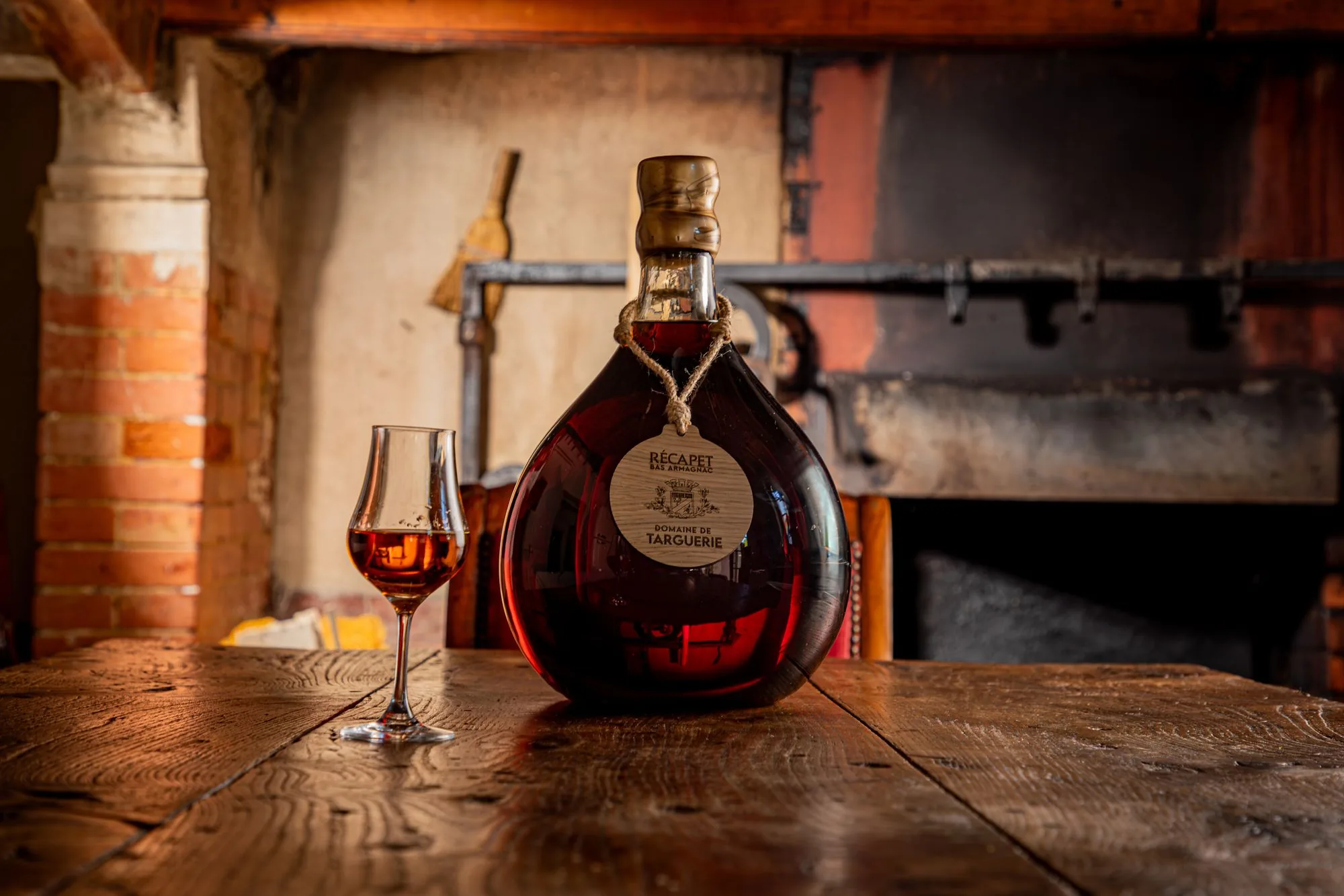 Bouteille et verre d'armagnac sur une table en bois