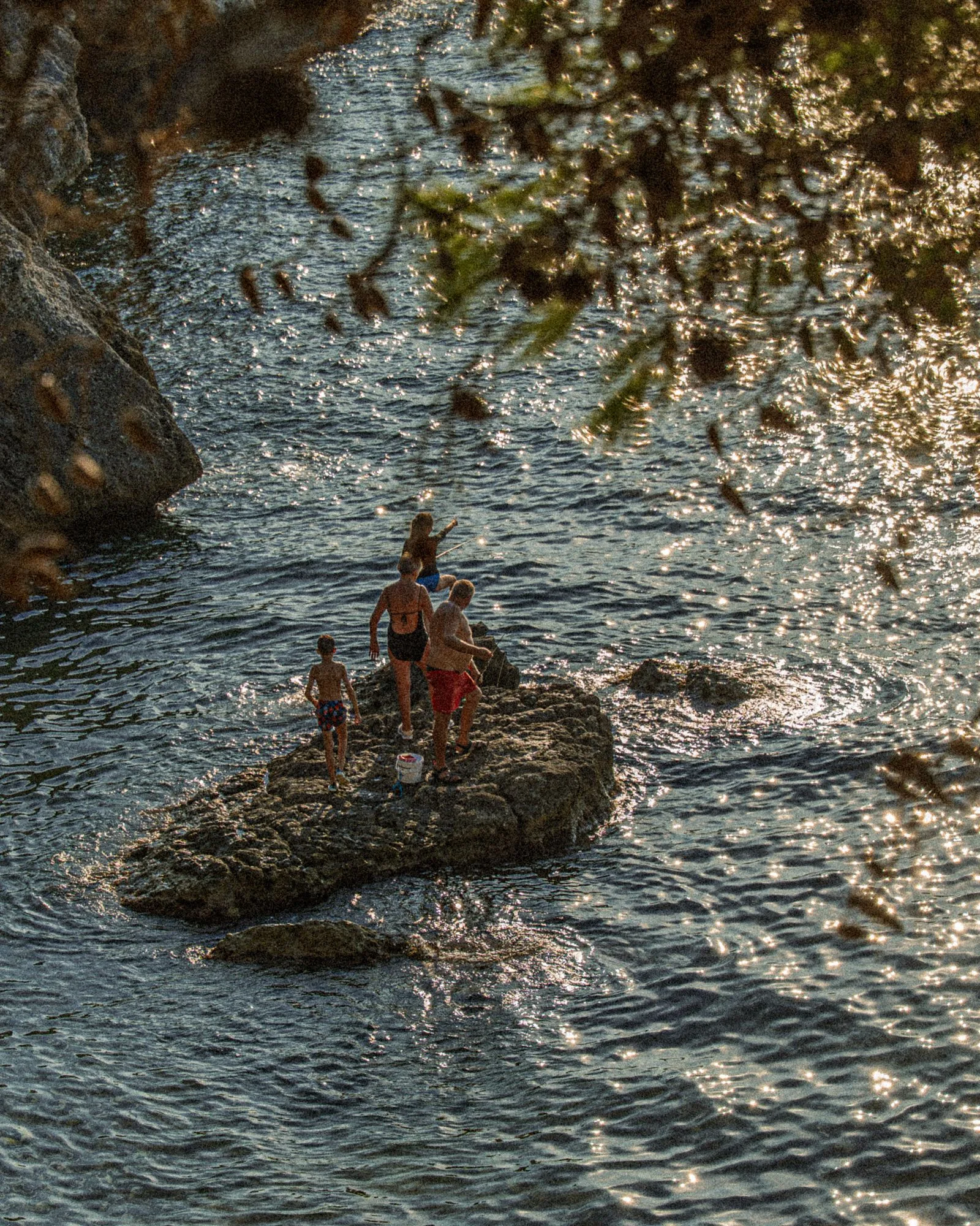 Des enfants sur un rocher au milieu de l'eau
