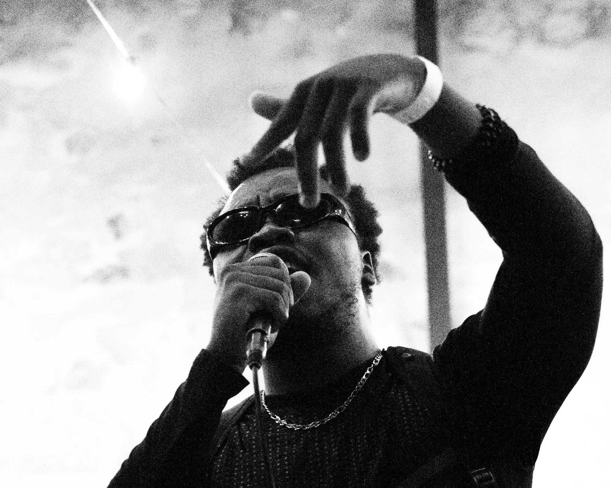 Rappeur à lunettes, main levée, sur fond clair